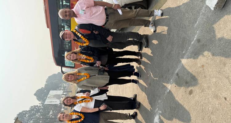 Eine Gruppe von Menschen, die draußen mit Girlanden stehen.