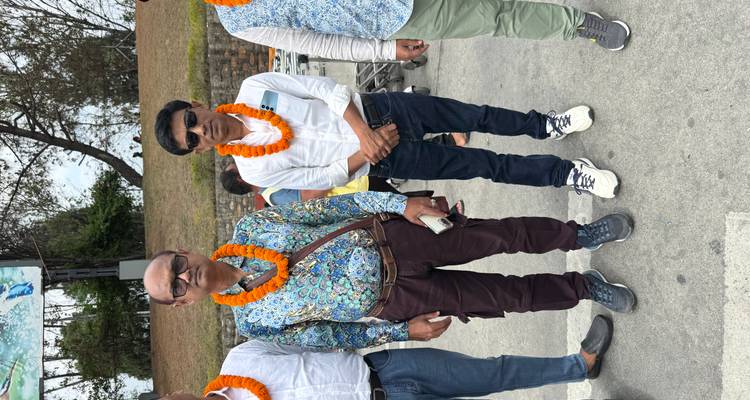 Zwei Männer posieren mit Girlanden im Freien.