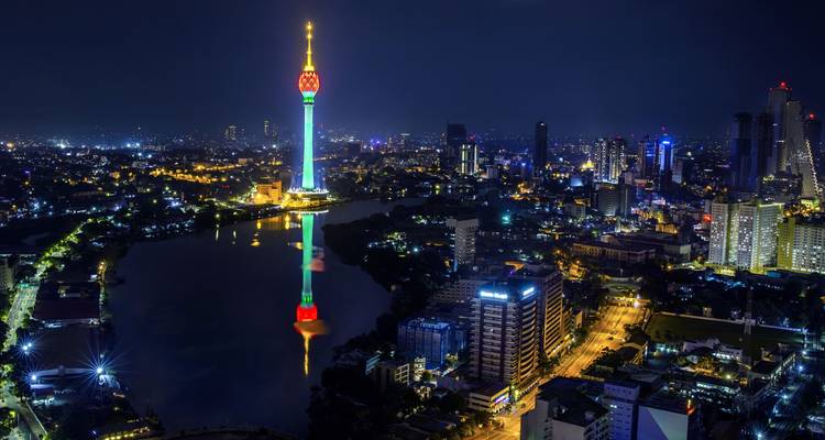 Een nachtelijk uitzicht op een stadshorizon met een hoge, verlichte toren.