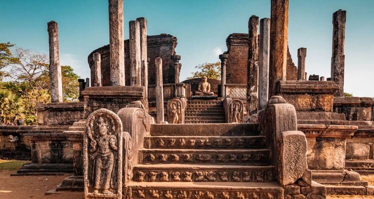 Antike Steinruinen und geschnitzte Wächter auf der archäologischen Stätte von Polonnaruwa im warmen Licht.