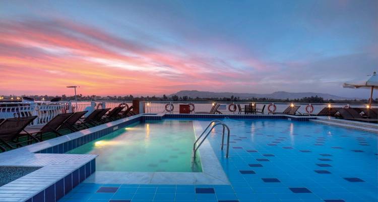 Ein Poolbereich mit Sonnenuntergangsblick über den Nil, stilvoll beleuchtet und einladend.