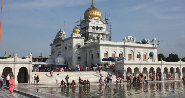 Sikh-Tempel mit goldenen Kuppeln und Besuchern.