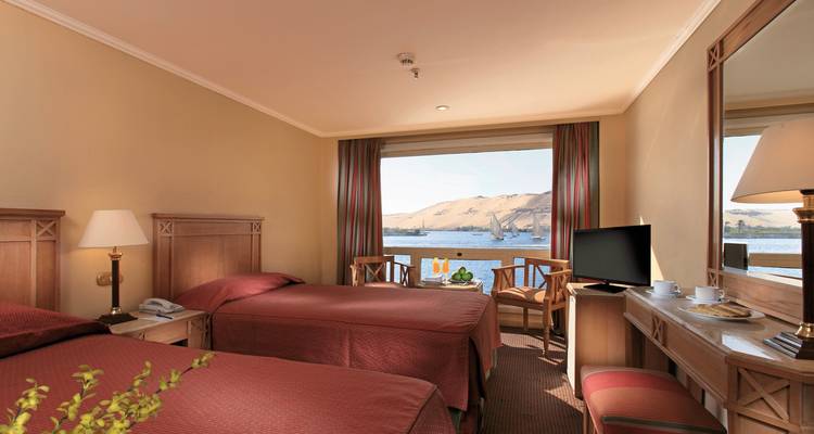 Ein Zweibettzimmer im Hotel mit Fensterblick auf den Fluss und die umliegende Landschaft.