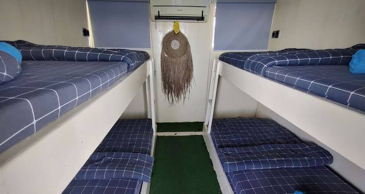 Inneres eines Schlafraums mit Etagenbetten und einfacher Einrichtung.