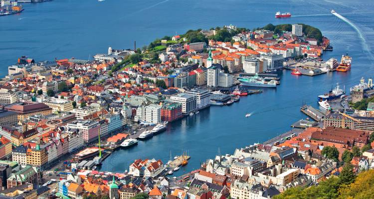 Aerial view of a coastal city with colorful buildings and a harbor.