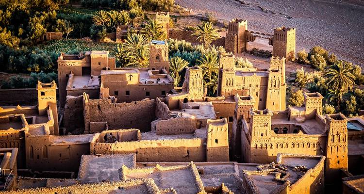 Luftaufnahme von Ait Benhaddou mit Lehmbauten und Palmen