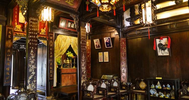 Historic wooden-interior house with antique furniture and traditional Vietnamese decorations.