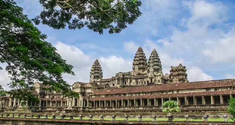 Les tours emblématiques et les longues galeries d'Angkor Wat entourées de verdure sous un ciel bleu