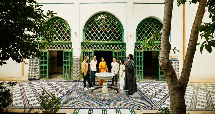 Groupe de personnes dans une cour avec une architecture complexe.
