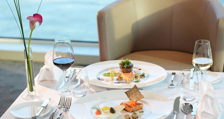 Gehobene Gastronomie mit elegant angerichteten Gerichten am Fenster.