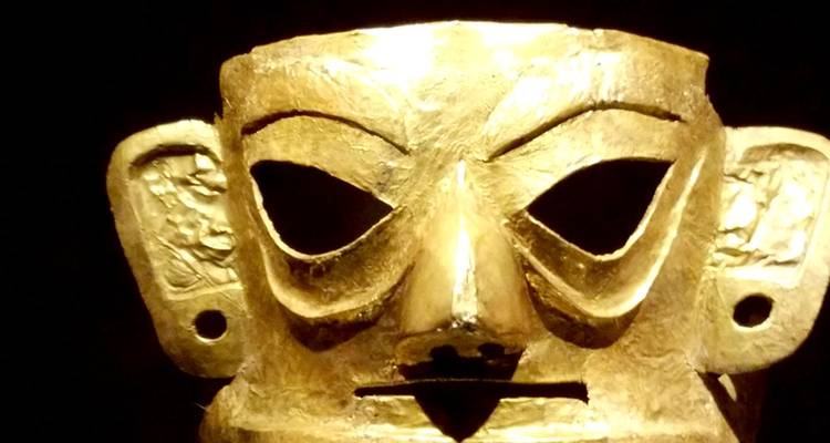 Goldene Gesichtsmaske als Ausstellungsstück.