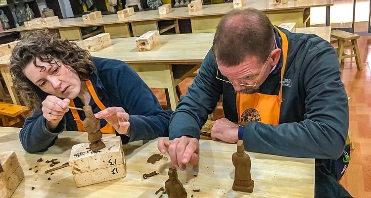 Menschen, die Tonfiguren formen.