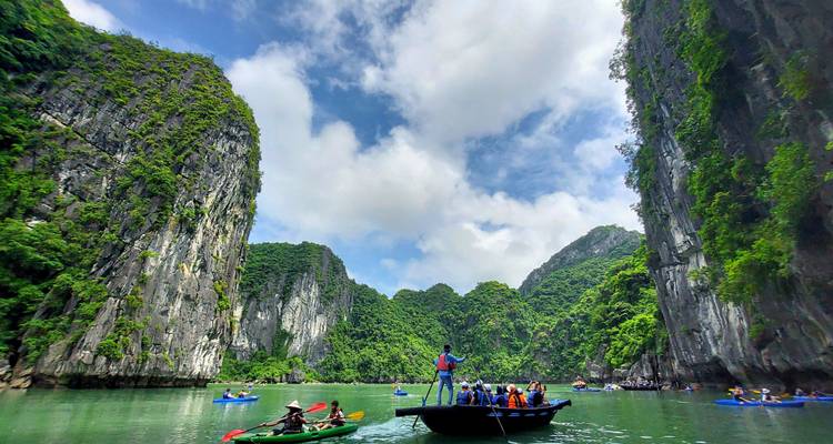Een rivier vol met toeristen in boten omringd door torenhoge kliffen.