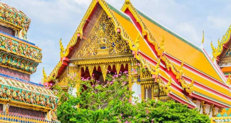 Les toits de temples thaïlandais aux couleurs vives et ornés ainsi que les pignons complexes se détachant sur un ciel aux tons pastel.