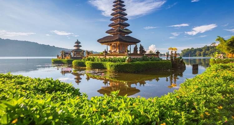 Temple aquatique serein entouré par un lac aux reflets et une verdure luxuriante à Bali.