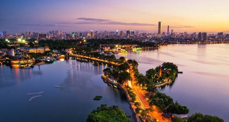 Schilderachtig uitzicht op een stadshorizon met uitzicht over een meer tijdens zonsondergang.