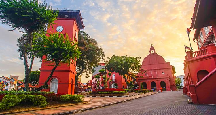 Edificio histórico colorido con torre de reloj durante la puesta del sol.