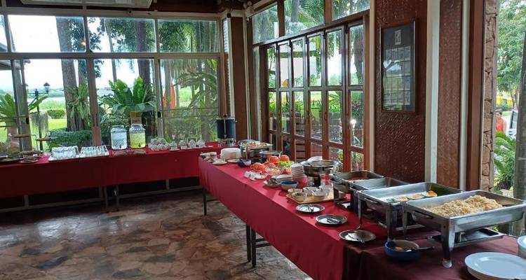 Buffetaufbau mit Speisen auf rot gedeckten Tischen.