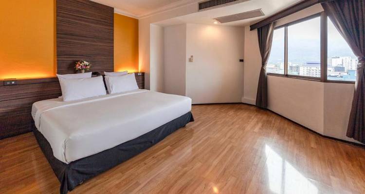 Geräumiges Hotelzimmer mit großem Fenster und Holzboden.