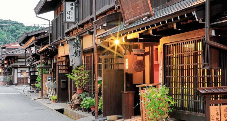 Traditionelle japanische Holzhäuser in einer Straßenumgebung.