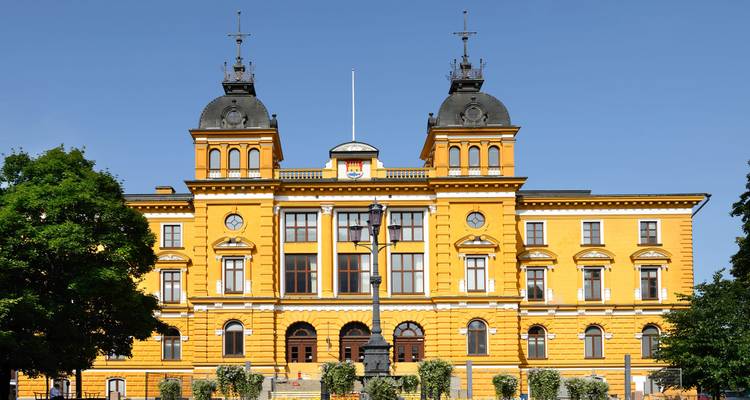 Prachtvolles gelbes Gebäude mit Türmen und einem Eingang.