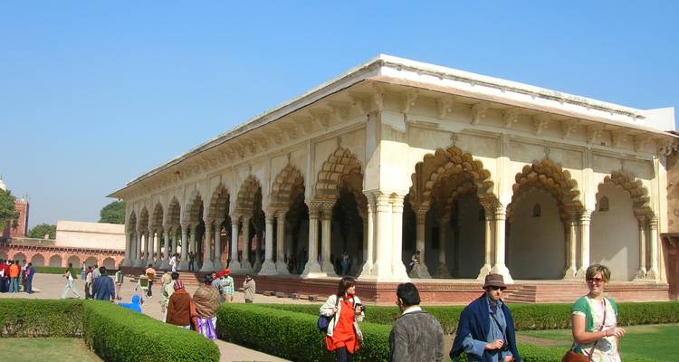 An architectural pavilion with intricate arches and tourists walking around.