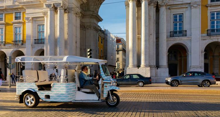 Persona conduciendo un tuk-tuk cerca de un sitio histórico.