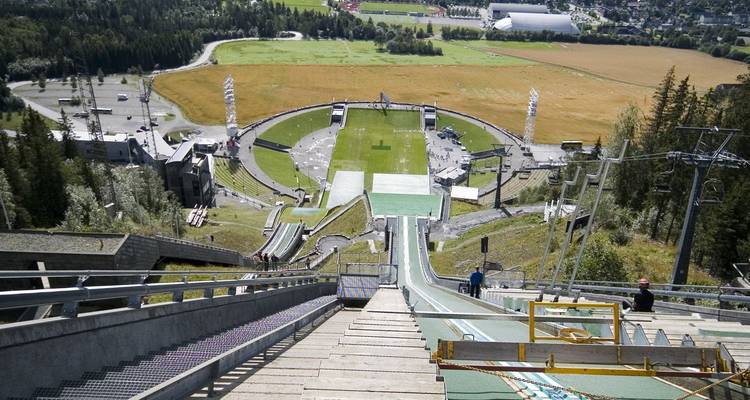 Una rampa de salto de esquí pronunciada con vistas a la arena olímpica de Lillehammer y el valle circundante.