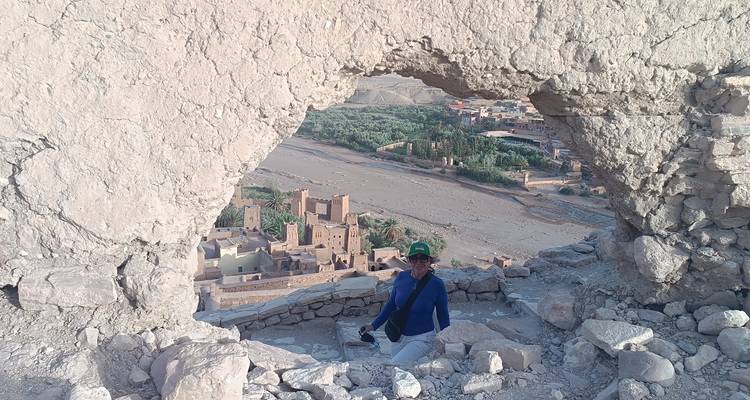 Personne devant une fenêtre en pierre naturelle donnant sur un site historique.