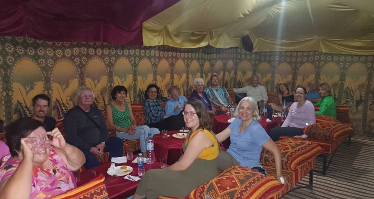 Groupe de personnes à l'intérieur d'un campement de tente traditionnelle.