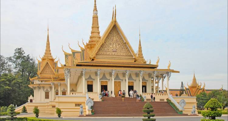 Menschen, die einen prächtigen Tempel mit kunstvoller Architektur betreten.