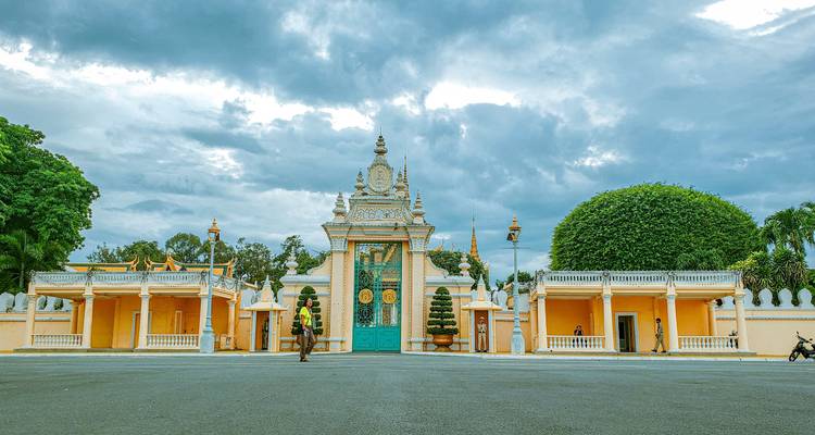 Person, die vor einem großen Tor bei bewölktem Himmel geht.