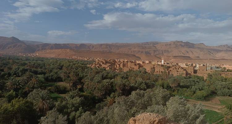 Une vallée verdoyante avec une ville nichée au pied de montagnes escarpées.