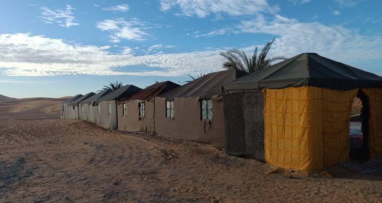 Rangée de tentes traditionnelles dans un campement du désert.