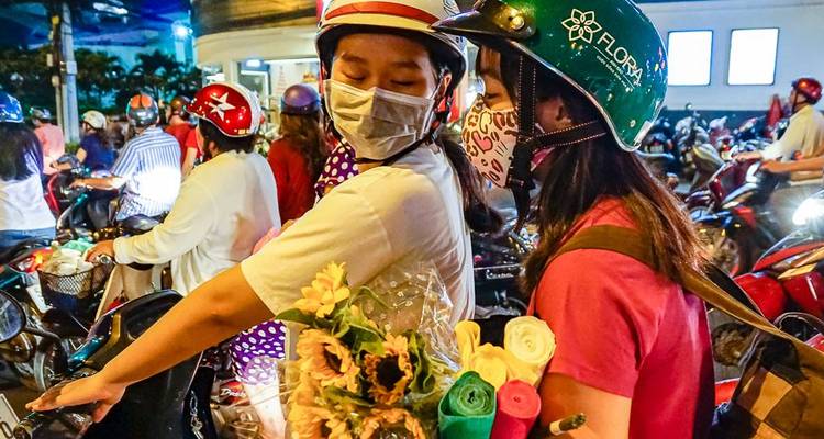 Groep mensen op motorfietsen in een drukke straat.