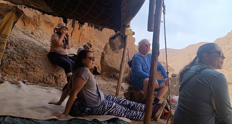 Des gens se détendent sous une tente dans une zone rocheuse.