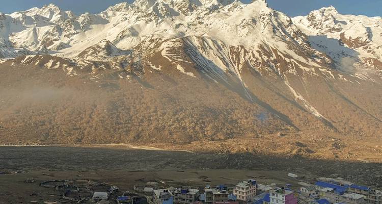 Snow-capped mountains with a village at the base.