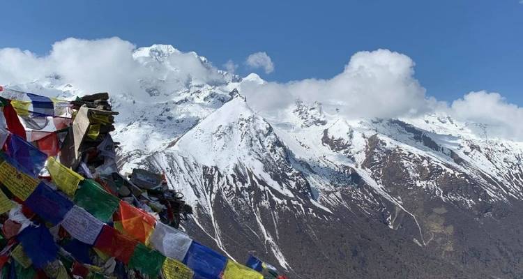 Prayer flags with snow-capped mountains in the background.