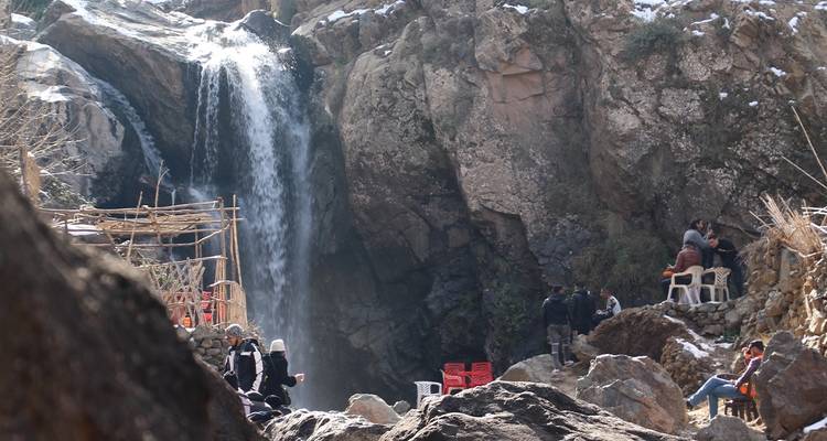 Waterval met rotsen en uitkijkpunt voor toeristen.