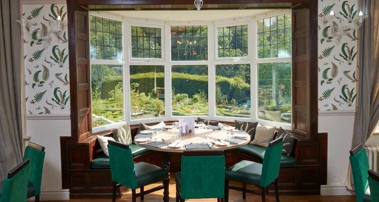 Dining area with a large bay window and outdoor view.