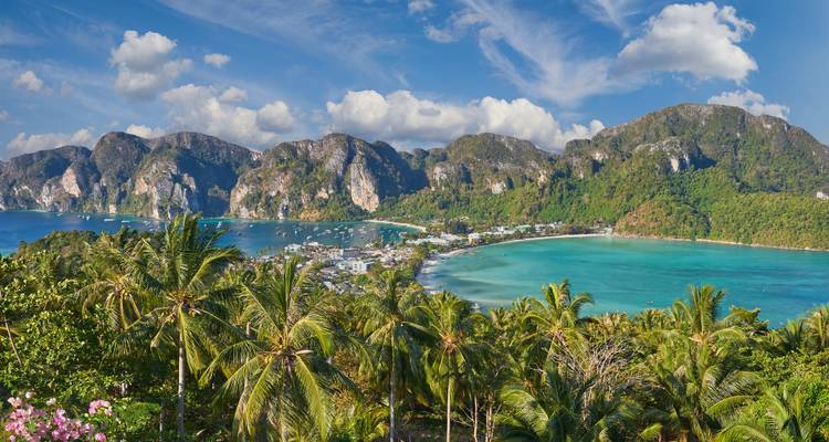 Malerische Aussicht auf eine tropische Bucht mit üppigen Bergen im Hintergrund.