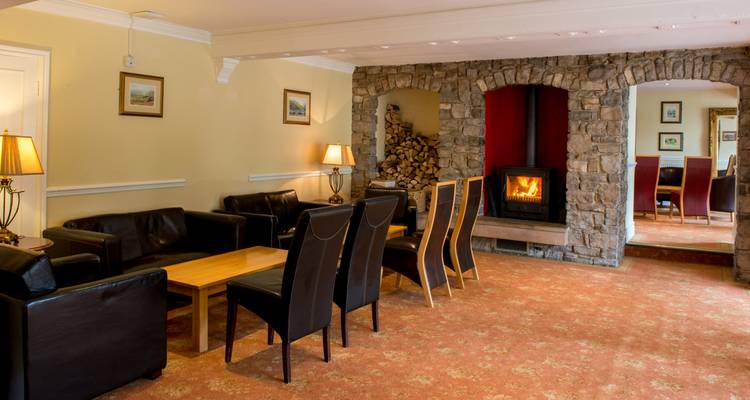 Ein Sitzbereich mit einem Steinkamin in einem gemütlichen Raum.