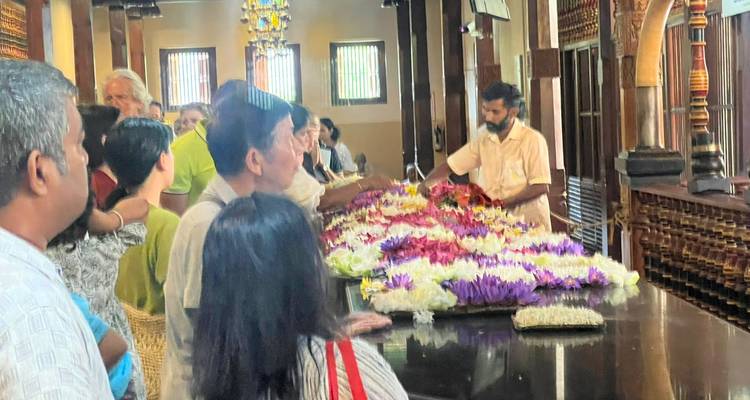 Les fidèles déposent des offrandes de lotus colorés sur un autel poli à l'intérieur d'une salle de temple.