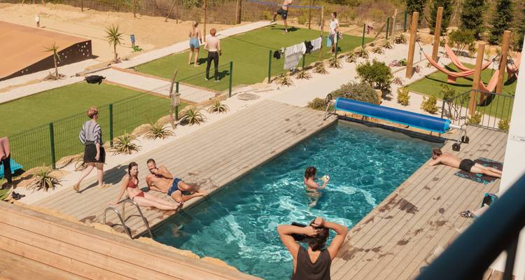 Mensen die genieten van vrije tijd rond een zwembad in een recreatiegebied.