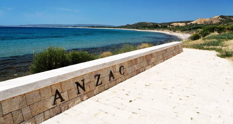 Stenen ANZAC-gedenkwand met uitzicht op het blauwe water van de kust van Gallipoli.