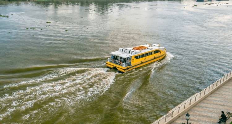 Gele boot die door bruin rivierwater beweegt.