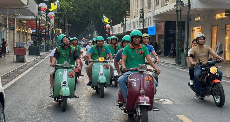 Eine Gruppe von Rollerfahrern auf einer Stadtstraße.