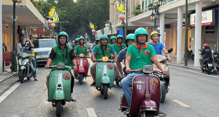 Gruppe von Menschen, die Roller auf einer Straße fahren.