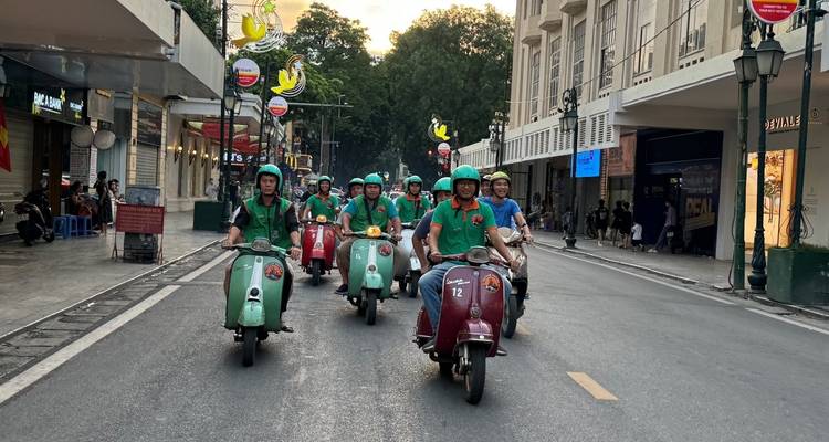 Eine Reihe von Rollern, die auf einer Stadtstraße gefahren werden.
