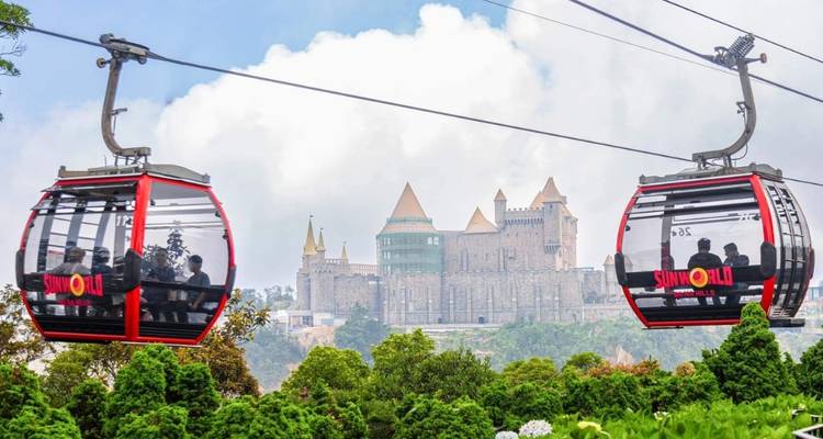 Teleféricos con gente viajando sobre una zona verde exuberante.